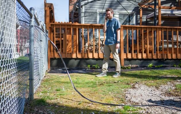 Person in back yard on telephone reporting downed line